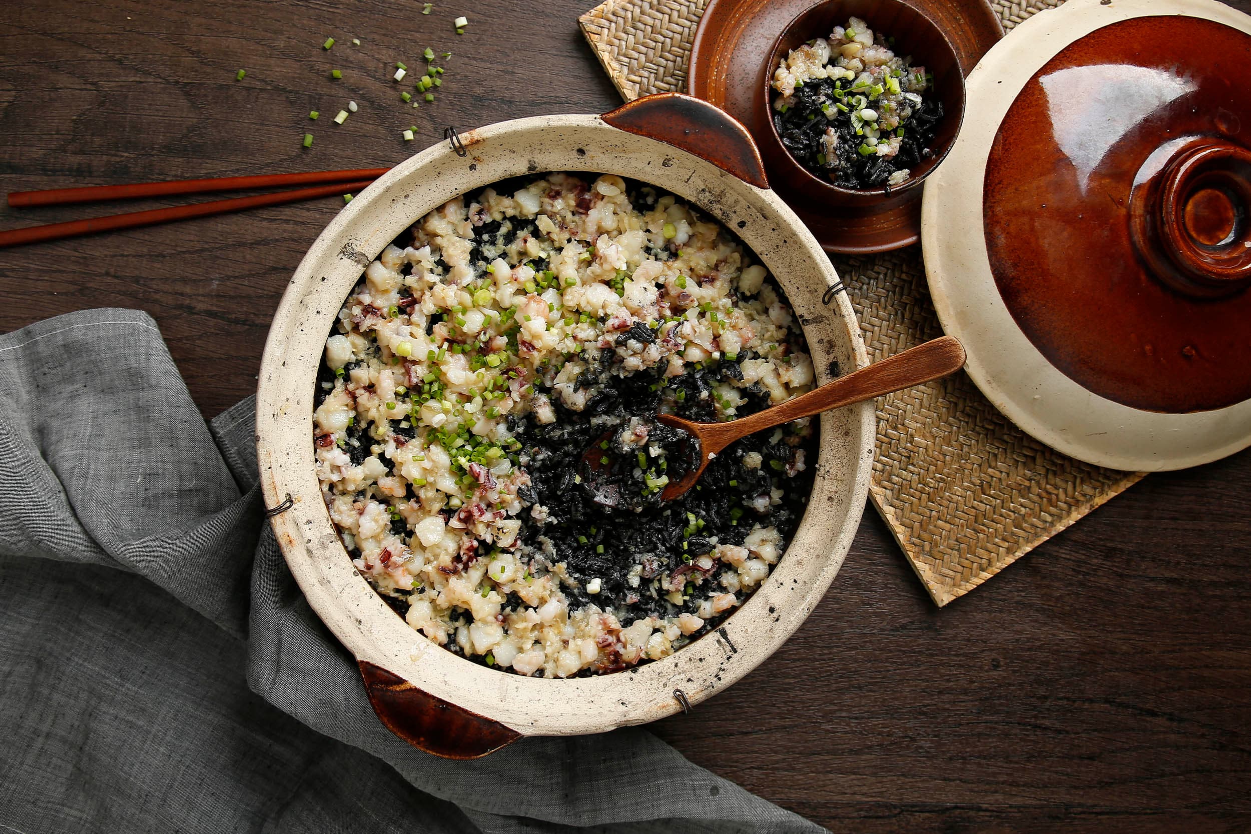Baked black ink rice with seafood in clay pot