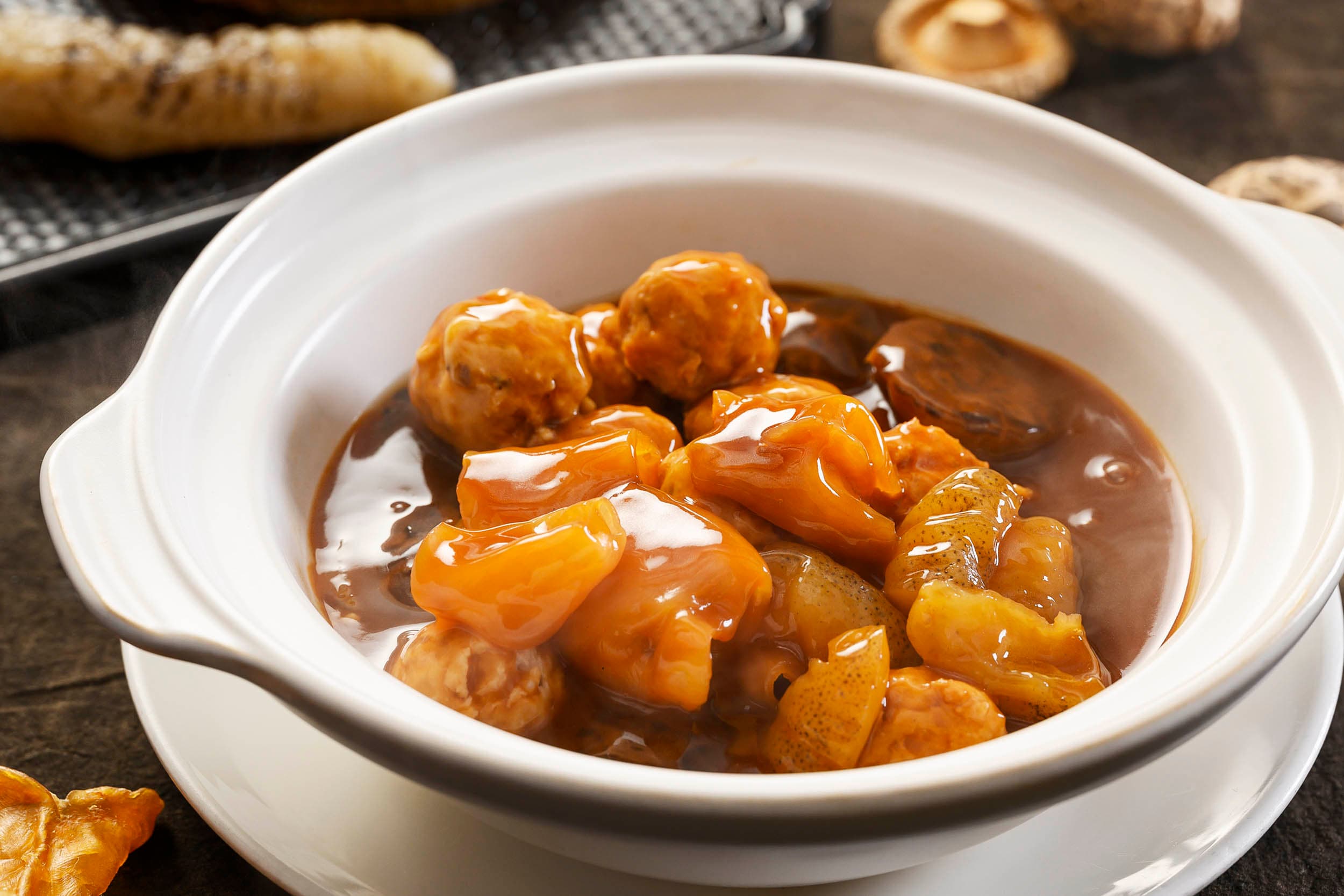 Braised fish maw and sea cucumber with meatballs in clay pot